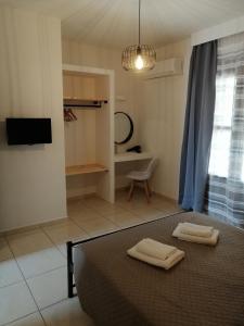 a bedroom with a bed with two towels on it at OASIS APARTMENTS in Livadia