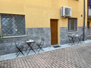 un gruppo di tavoli e sedie di fronte a un edificio di B&B San Luca a Bologna