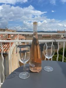 - une bouteille de vin et 2 verres à vin sur une table dans l'établissement 2 pièces climatisé en duplex avec terrasse, à Aix-en-Provence