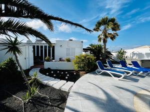 a group of blue chairs sitting on a patio at Casa Alizée, heated pool, hot tub in Playa Blanca