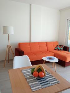 sala de estar con sofá y mesa con un bol de fruta en Sunshine, What else?, en Las Palmas de Gran Canaria