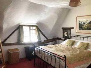 a bedroom with a bed and a window at Cider Mill Cottage in Alderton