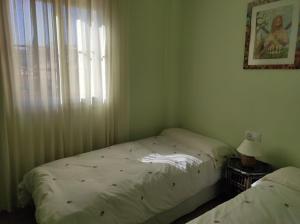 1 dormitorio con 2 camas y ventana en APARTAMENTO PERFECTO, en La Antilla