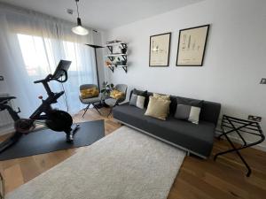 a living room with a couch and a gym at Peloton Organic Health Apartment in Angel, Old Street, Islington in London