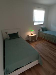 1 dormitorio con 2 camas y mesa con lámpara en Casa da avó Zita, en Pombal