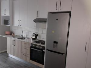 a kitchen with a refrigerator and a stove top oven at Cederberg Estate in Cape Town