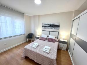 ein Schlafzimmer mit einem Bett mit zwei Kissen darauf in der Unterkunft EL NORTE in Viveiro