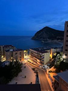a view of a city at night with the ocean at Apartamento, La Cala Vicent&Alba in Cala de Finestrat