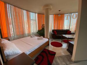 1 dormitorio con 1 cama y sala de estar en Hotel W Bush Square, en Fushë-Krujë