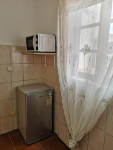 a microwave sitting on a shelf next to a window at Old house in Tarrafal
