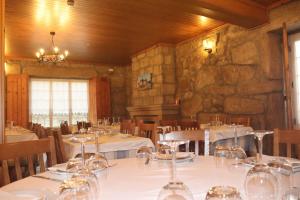 een eetkamer met tafels en stoelen met wijnglazen bij Casa do Destro in Ponte da Barca