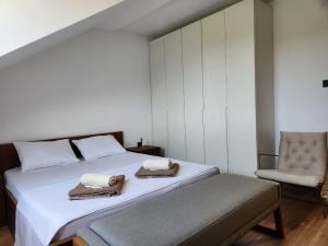 a bedroom with two beds and a chair at Dodoši Ksenija in Cetinje