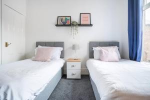 two beds sitting next to each other in a bedroom at The Crown, Modern and Stylish Home from Home in Darlington