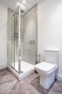 a white bathroom with a shower and a toilet at The Crown, Modern and Stylish Home from Home in Darlington