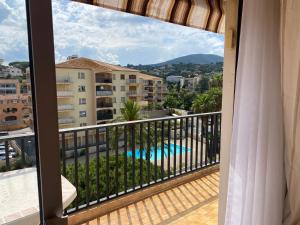 een balkon met uitzicht op een zwembad en gebouwen bij La Palmeraie 2 chambres in Sainte-Maxime