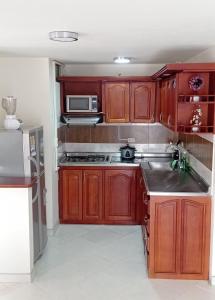 eine Küche mit Holzschränken und einer Mikrowelle in der Unterkunft Apartamento con vista al embalse in Guatapé