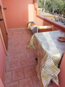 ランペドゥーザにあるCasa Vacanze Cala Pisanaのテーブル付きのタイルフロアの客室です。