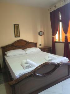 ein Schlafzimmer mit einem großen Bett und einem Waschbecken in der Unterkunft Hotel W Bush Square in Fushë-Krujë