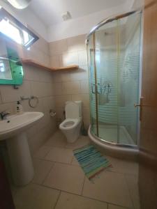 ein Bad mit einer Dusche, einem WC und einem Waschbecken in der Unterkunft Hotel W Bush Square in Fushë-Krujë
