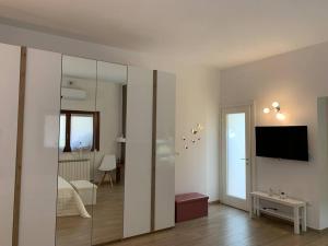 een kamer met een bed, een tv en een spiegel bij La Taverna dei Tre Micetti in Villafranca di Verona