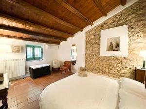 - une chambre avec un lit et un mur en pierre dans l'établissement Agriturismo Bannata, à Piazza Armerina