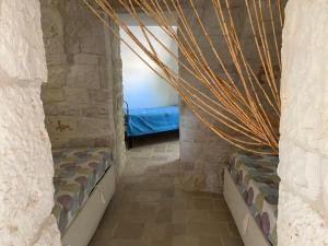 Trullo Raimondo في مارتينا فرانكا: غرفة نوم بسريرين في جدار حجري