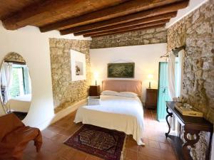 1 dormitorio con cama y pared de piedra en Agriturismo Bannata, en Piazza Armerina