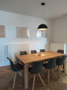 een eetkamer met een houten tafel en stoelen bij Pension HoPeLa in Gotha