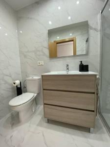 a bathroom with a toilet and a sink and a mirror at Apartamento NyA Zamora in Zamora