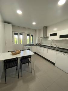 a large white kitchen with a table and chairs at Apartamento NyA Zamora in Zamora +5 photos