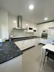 a kitchen with white cabinets and a black counter top at Apartamento NyA Zamora in Zamora