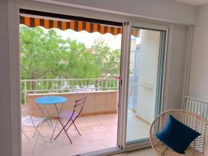 d'une porte-fenêtre avec une table et des chaises sur un balcon. dans l'établissement T2 avec garage possible, port et plage à moins de 5 minutes à pied !, à Bandol