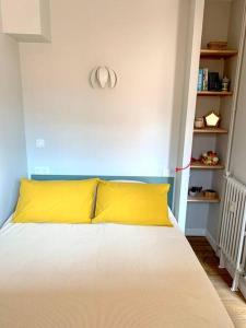 - un lit avec un oreiller jaune dans l'établissement T2 avec garage possible, port et plage à moins de 5 minutes à pied !, à Bandol