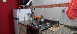 een kleine keuken met een fornuis en een koelkast bij Dpto económico para tres en Ballester con TV in Villa Ballester