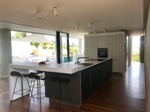 a kitchen with a large island with a sink and stools at Contemporaine in Bandol