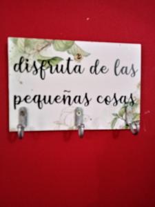 un panneau sur une porte rouge avec les mots «Resiina de las peñas» dans l'établissement Dpto económico para tres en Ballester con TV, à Villa Ballester