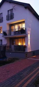 a large white building with a lit up window at Villa Rosa pokoje u Marzeny in Władysławowo
