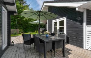 a table and chairs with an umbrella on a deck at Gorgeous Home In Samsø With Kitchen in Onsbjerg