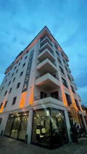 duży biały budynek z pomarańczowymi światłami w obiekcie Melissa Suite Otel w mieście Trabzon