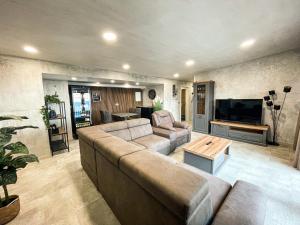 uma sala de estar com um sofá grande e uma televisão em Wine Paradise - Glamping resort em Marezige