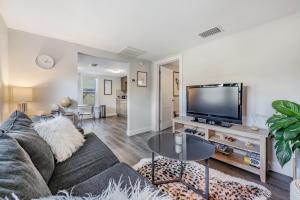 a living room with a couch and a flat screen tv at The Urban Nest in Tampa