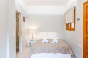 a white bedroom with a bed with towels on it at Aroma Accommodations in Kivérion