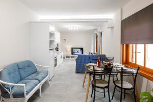 a living room with a blue couch and a table at Aroma Accommodations in Kivérion