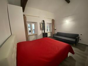 a bedroom with a red bed and a couch at Casa Danilo in Cadegliano Viconago