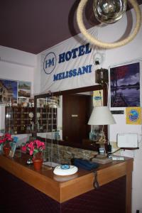 un escritorio de hotel con un cartel en la pared en Melissani hotel en Sami