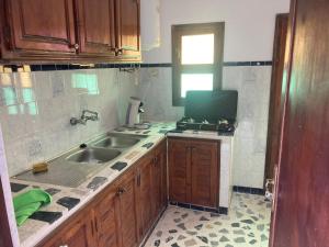 a kitchen with a sink and a tv in it at Villa Bellouti in Tangier