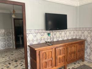a flat screen tv on a wall with a wooden cabinet at Villa Bellouti in Tangier
