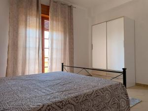 1 dormitorio con 1 cama con tocador y ventana en Casa Vacanza Torre di Mezzo - Tramonto, en Marausa
