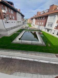 a pool in the middle of a courtyard with buildings at Apartamentos aguanaz in Entrambasaguas