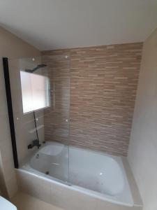a bathroom with a bath tub with a glass shower at Apartamentos aguanaz in Entrambasaguas